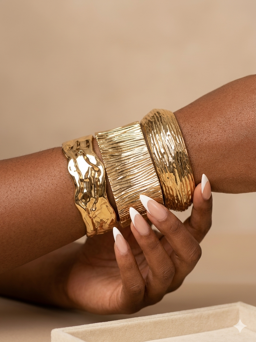Three gold textured bangles on a wrist