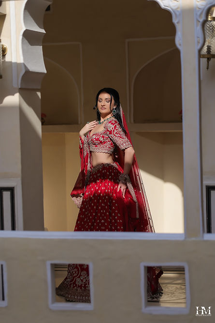 Fashion editorial portrait of a woman in a red traditional outfit in an architectural setting