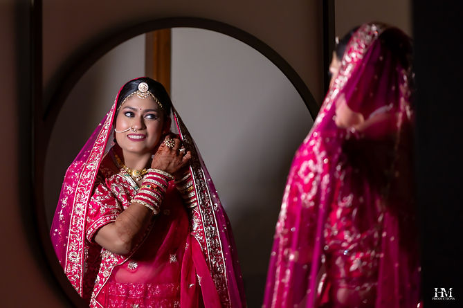 Indian bride looking into a mirror during her wedding preparations