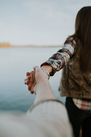 A Couple Holding Hands in front of water