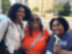 Three Black women smile for the camera in front of Cleveland City Hall