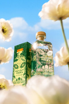 Vodkaflaskor omgiva av vita blommor.