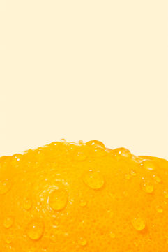 Apelsin med vattendroppar mot en ljus bakgrund.