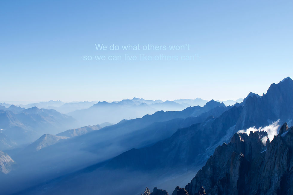 Blue mountain range at sunrise with misty layers. Text reads: "We do what others won’t so we can live like others can’t." Serene and inspiring.