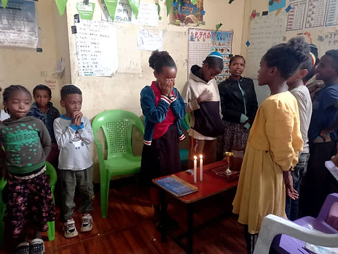 children observing Shabbat by lighting candles