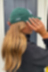 Business owner smiling in a green cap, representing Design by KJ's client-first approach