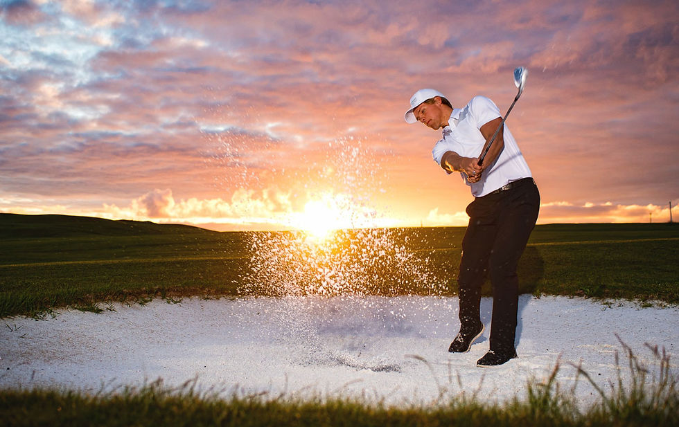 Golfer hitting a bunker shot at Bodø Golfpark during sunset