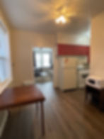 Studio apartment eating area and partial view of the kitchen from the closet.