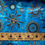 Thumbnail: Black w/Gold on Blue Sun and Stars Odyssey OY-156 Cotton Batik Fabric