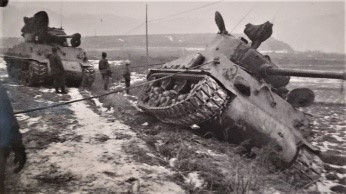 Tank being winched back on a narrow Korean road during the Korean War. Public domain photo