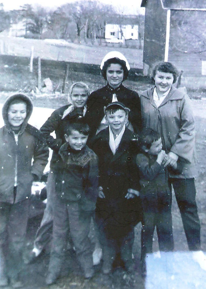 Marie in nurse uniform with cousins and other children. Contributed photo