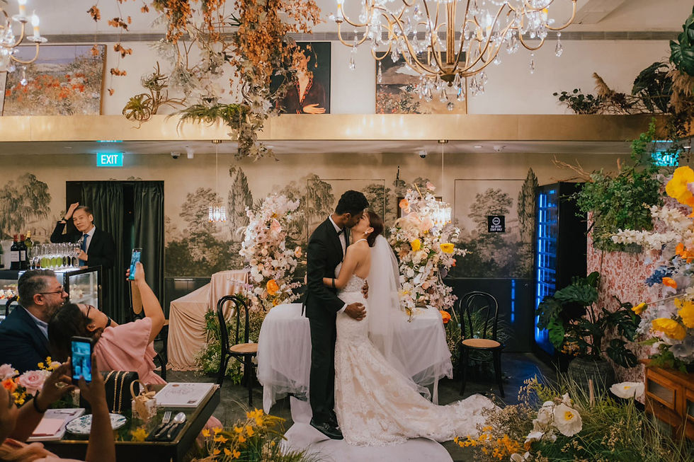 Newlyweds share a romantic kiss at Singapore's top wedding venue, set amidst Victorian-styled dining with classic French flavours.