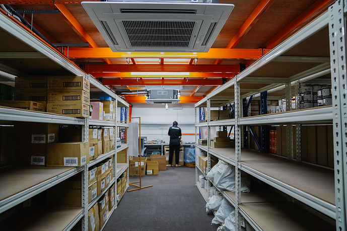 Efficient warehouse operations: Employee packing amidst an abundance of resources.