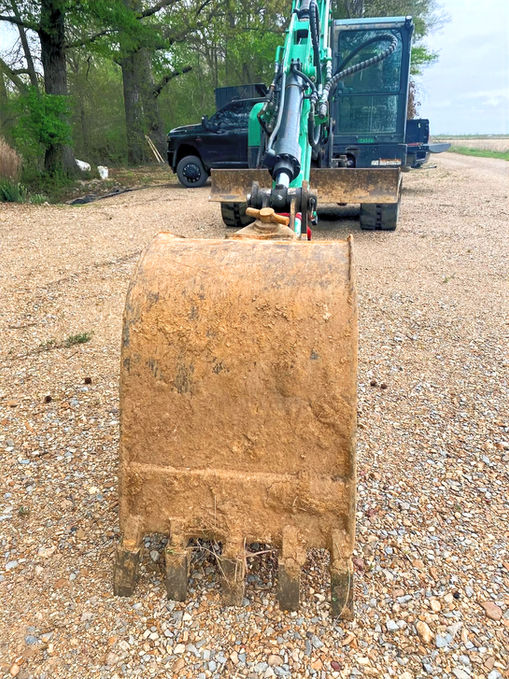 Front picture of excavator bucket on the ground.