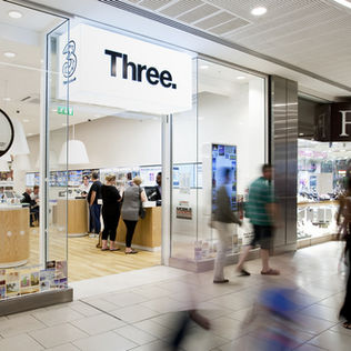 Three store entrance with people shopping inside and