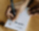 Hand filling in custom notepad with a pen.