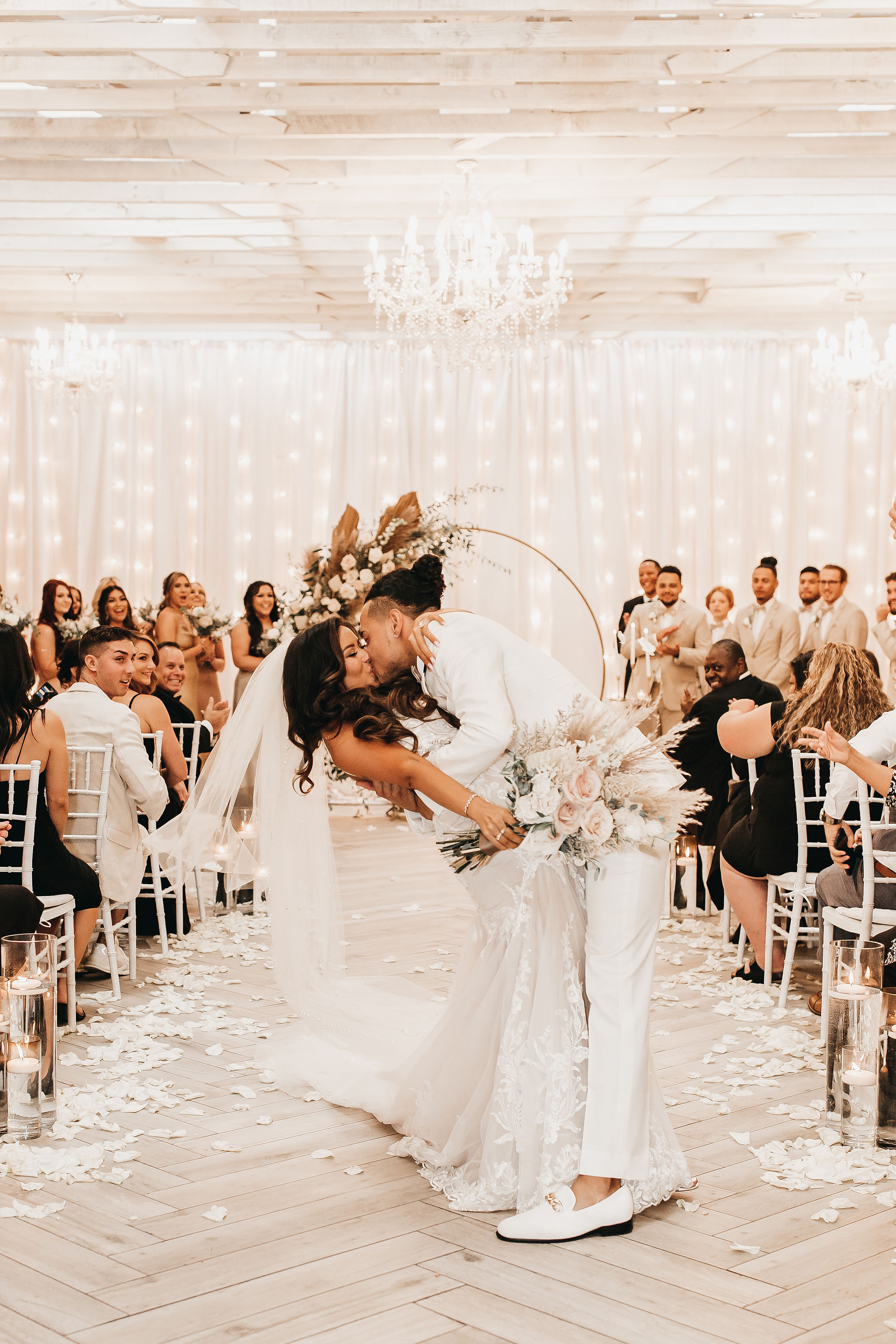 custom groom ivory tuxedo with champagne trim kissing bride at Tre Bella wedding in AZ