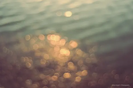 Bokeh light balls on water at sunset in Lattes, France