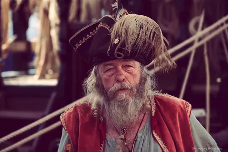 Man dressed as a pirate standing on a boat in Sète, France.