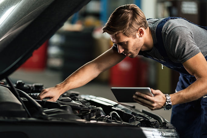 car-mechanic-examining-engine-malfunction-while-using-touchpad-auto-repair-shop.jpg