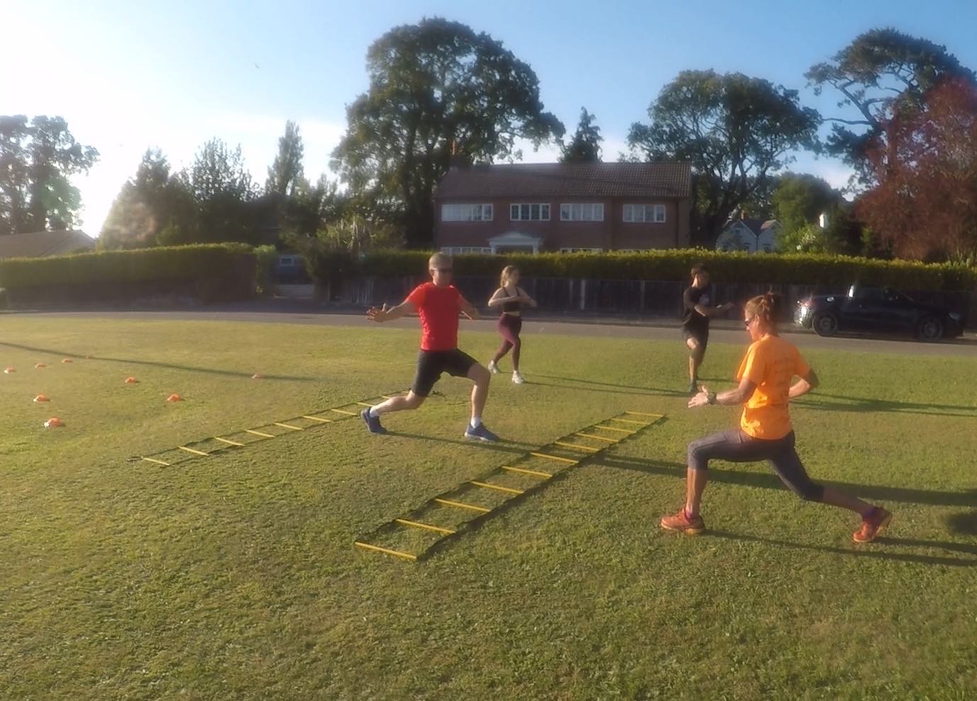 Group conditioning session using agility ladders and movement drills.