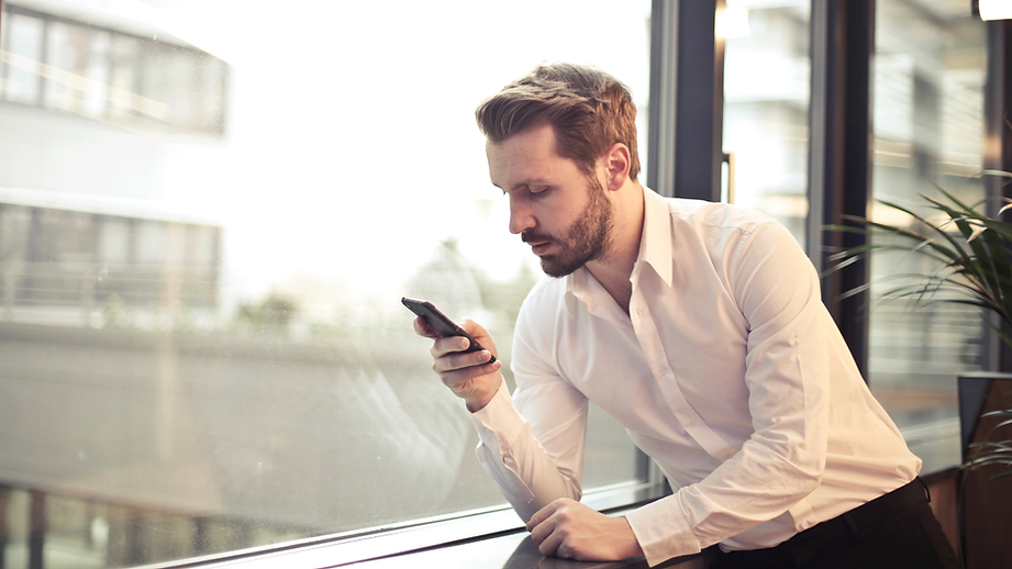 Man reading a message on his phone .png