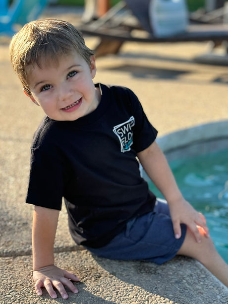 survivor Daniel sitting on edge of pool learning water safety