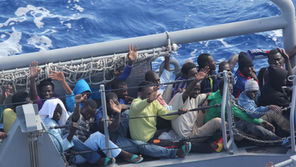 Distressed persons wave after being transferred from the amphibious transport dock ship USS San Antonio (LPD 17) to Armed Forces of Malta offshore patrol vessel P52. San Antonio provided food, water, medical attention, and temporary shelter to the rescued. San Antonio rescued 128 men adrift in an inflatable raft after responding to a call by the Maltese Government.