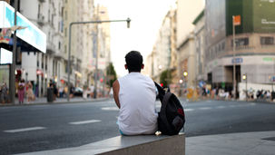 Vista posteriore di un uomo seduto su una panchina in strada a Madrid, catturando la solitudine urbana - https://www.pexels.com/it-it/foto/uomo-strada-da-solo-urbano-10945545/