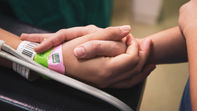 Primo piano di mani, che trasmettono comfort e supporto in un ambiente sanitario.