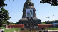 Il monumento Battle of the Nations a Lipsia con un cartello di protesta contro una manifestazione neonazista - ¡0-8-15!, CC BY-SA 3.0, via Wikimedia Commons
