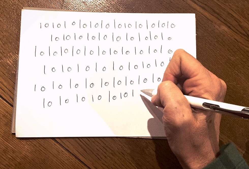 a hand writing circles and dashes on a piece of paper
