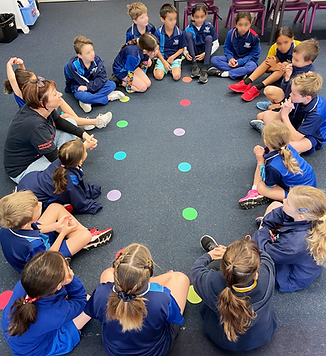 Shona sitting in a circle of young students