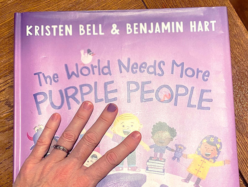 image of the book The World Needs More Purple People with a hand on top of it with one purple painted nail