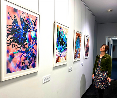 Shona looking at her framed artwork on exhibit