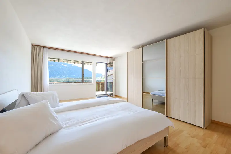Schlafzimmer einer 2.5 Zimmer Ferienwohnung in Laax mit Bergsicht