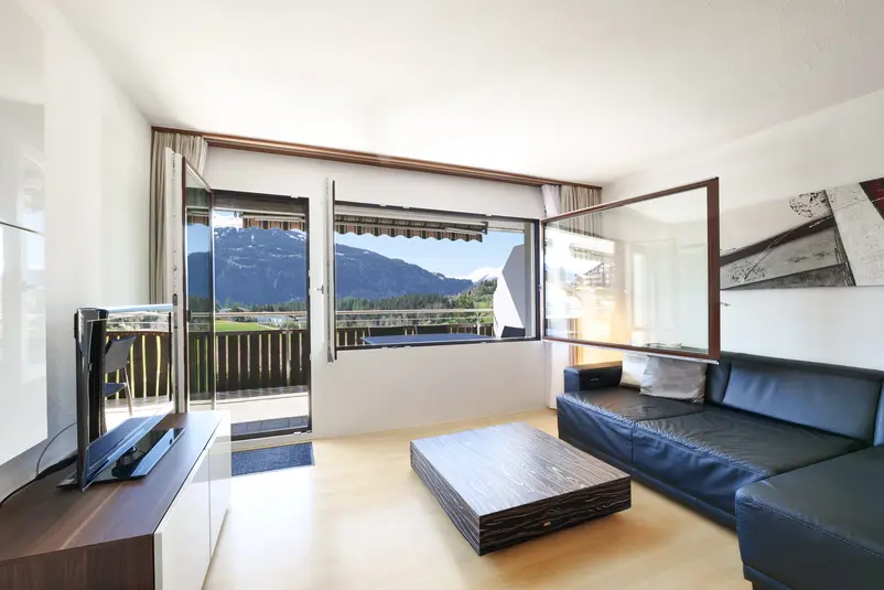 Wohnzimmer einer 2.5 Zimmer Ferienwohnung mit Balkon und Bergsicht