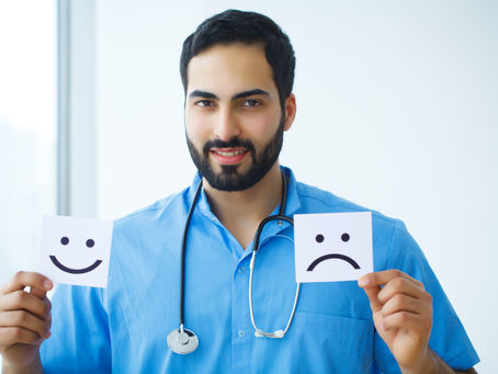 A doctor holding cards with smiley and frowny faces, representing the equilibrium of positive and negative feedback in healthcare.