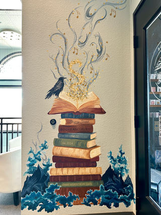 Stack of books, mountains, blue smoke, raven and gold magic coming out of open book.