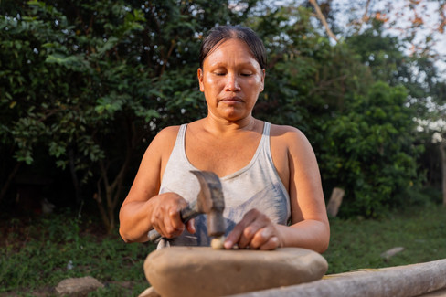 Amazonian woman processing murumuru seeds by hand, adding value to a sustainable non-timber forest product.