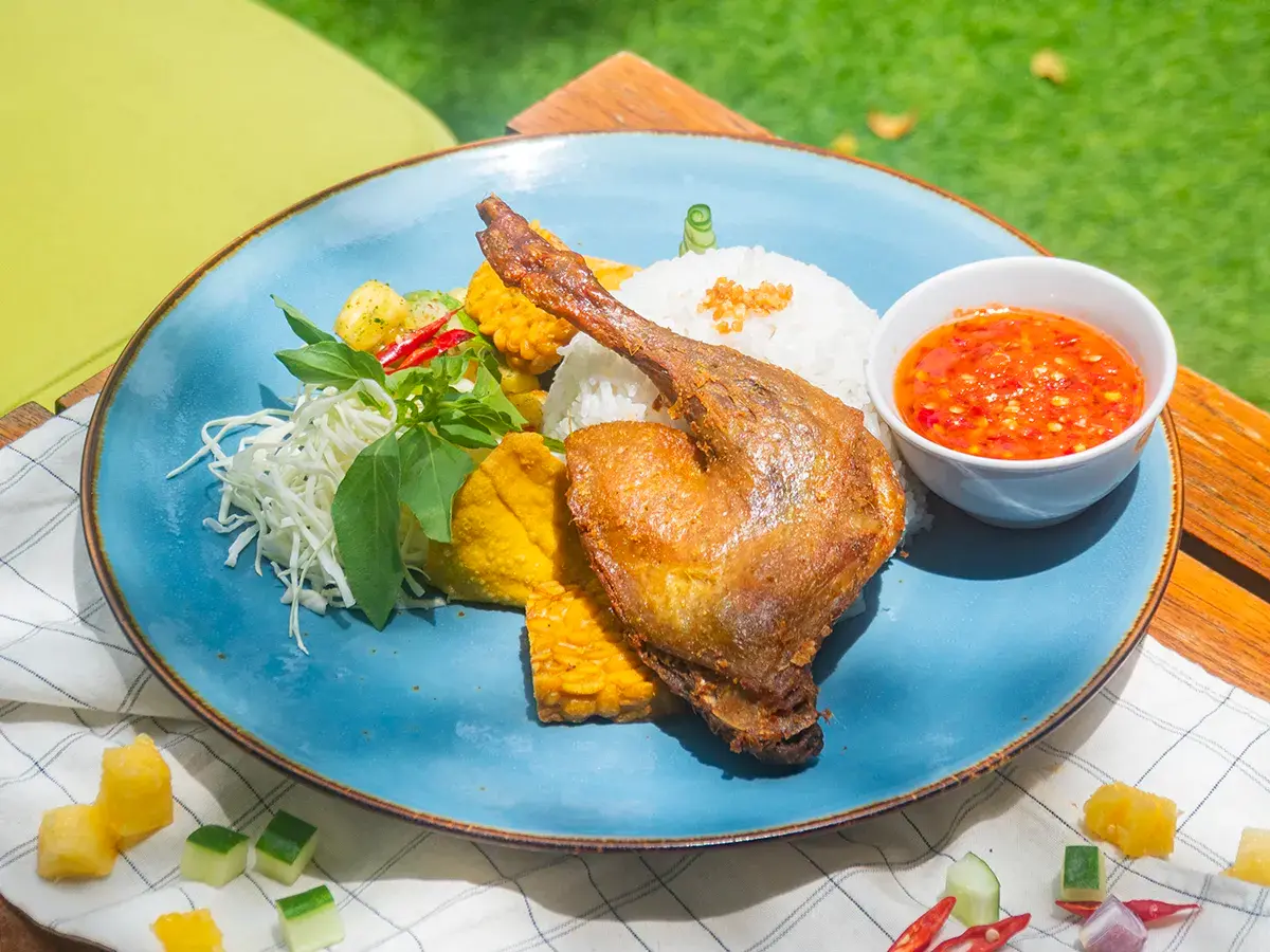 Bebek Goreng Penyet dengan kulit crispy, daging empuk, dan sambal dadak segar yang pedas.