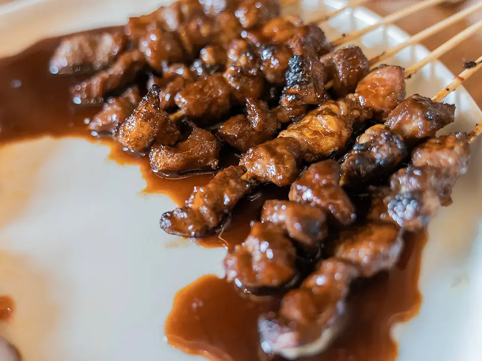 Sate Ayam Kecap dengan daging ayam bakar yang disajikan dengan saus kecap manis, irisan bawang, tomat, dan cabai rawit.