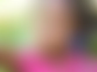 Une petite fille aux cheveux crépus qui sourit
