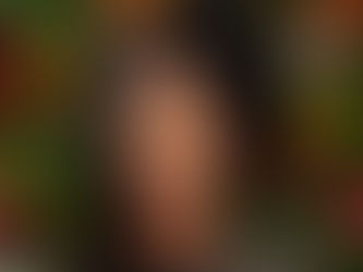 Une femme noire souriante qui présente 2 textures de cheveux sur la tête côté gauche défrisé côté droit frisé