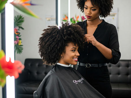 Une femme aux cheveux texturés qui se fait coiffer dans un salon