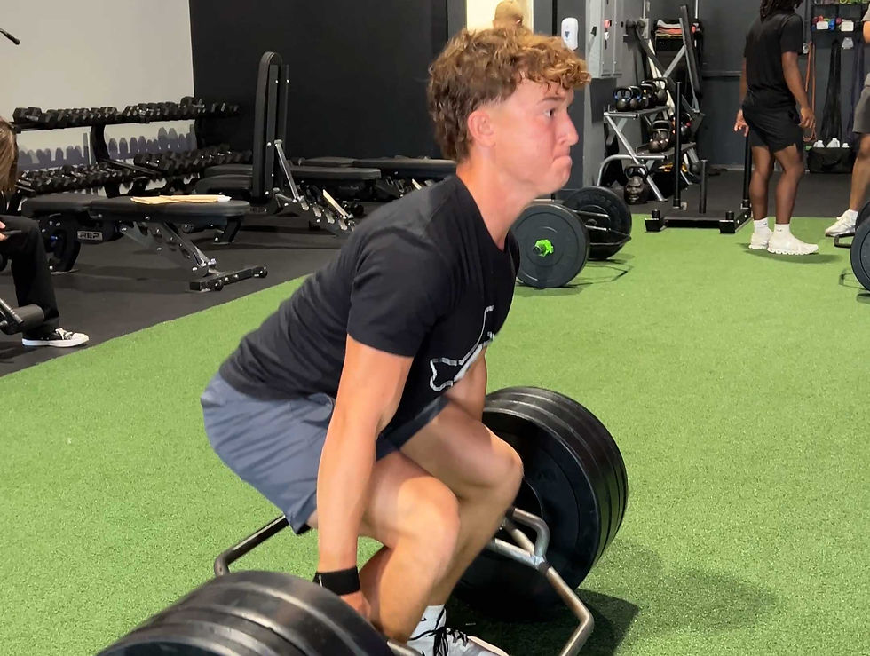 high school football player performing trap bar deadlift
