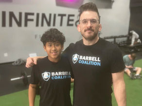 Youth athlete and coach smiling for camera together at Barbell Coalition