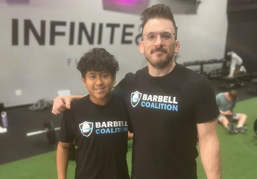Youth athlete and coach smiling for camera together at Barbell Coalition