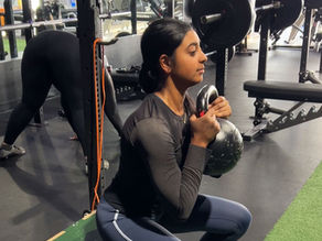 young female athlete performing kettlebell strength exercise