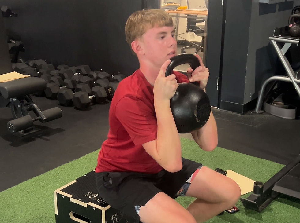 youth athlete performing kettlebell squat exercise